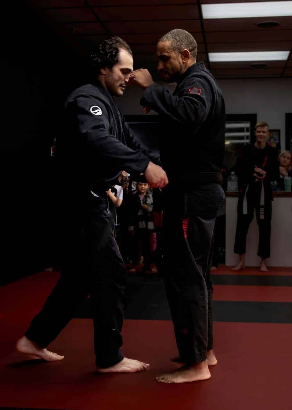 West Karate & Brazilian Jiu Jitsu instructor tying new belt on student after getting belt upgrade.