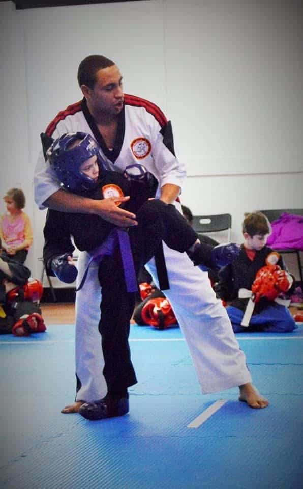 West Karate & BJJ instructor helping little technicians student learn proper techniques.