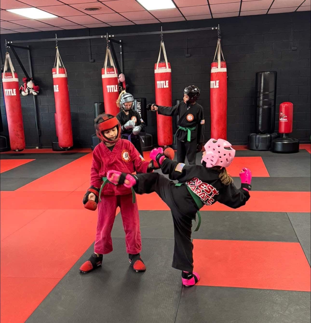 West Karate & BJJ students practicing during karate class wearing sparring gear.